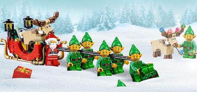 A cartoon picture of Lego elves pulling a Lego Santa and his sled with reindeer nearby in fresh white snow.