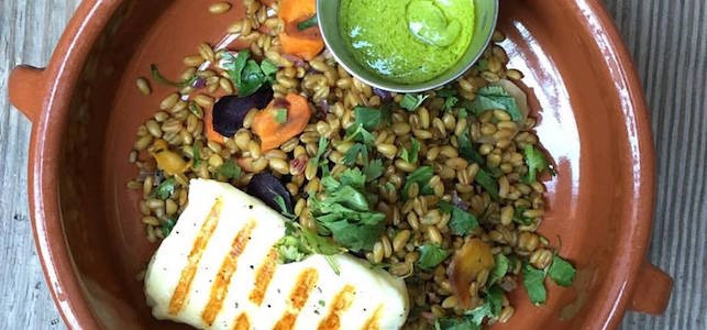 A dish from The Smile with fresh greens, grilled chicken, and brown rice with carrots.