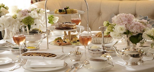 A table set for brunch or tea time with fresh flowers and white linens at The Lowell Hotel in NYC.