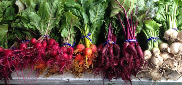 Fresh and brightly colored vegetables at an outdoor farmers' market in NYC.