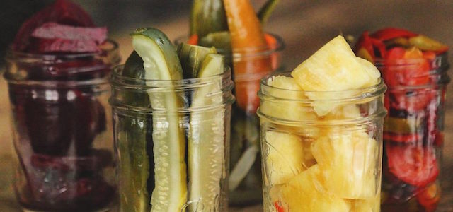 Glass Mason jars with fresh fruit and vegetables.