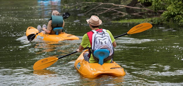 Two kayaks at The Ravine in Prospect Park paddling during the day on the stream. 