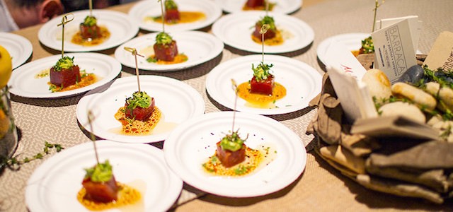 A table of small appetizer sample sizes of brightly colored food.