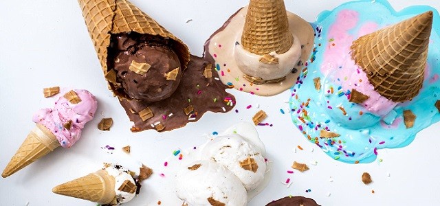 Melted ice cream cones spilled on a white counter with broken cones and rainbow sprinkles.