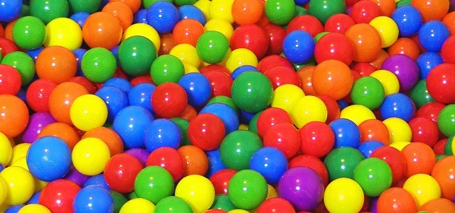 A ball pit filled with plastic rainbow colored balls.
