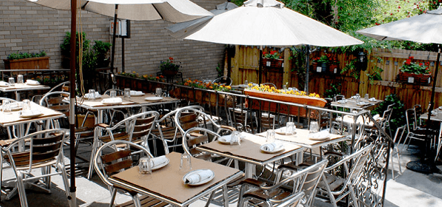 An exterior view of Medi Wine Bar's outdoor seating area with tables and umbrellas.