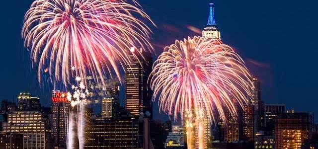 Fireworks exploding into bright colors in NYC at night.
