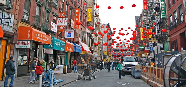 A colorful street in Chinatown with bright red stringed balloons.