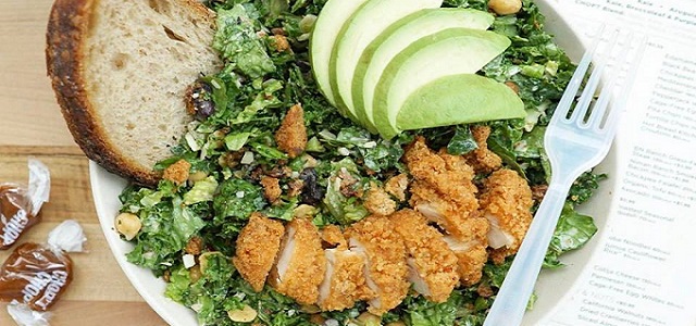 A close up image of a salad bowl from Chopt in New York City with green salad, crispy chicken, and fresh green apple toppings.