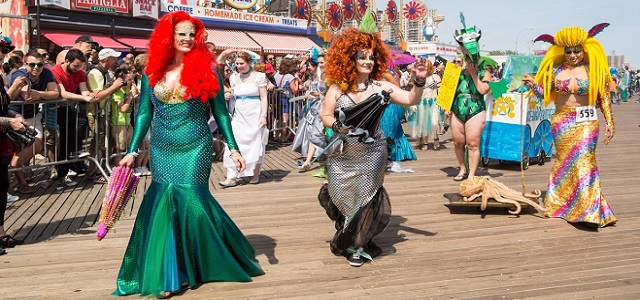 A group of women walking on the Coney Island Boardwalk dressed as mermaids at the yearly Mermaid Parade.