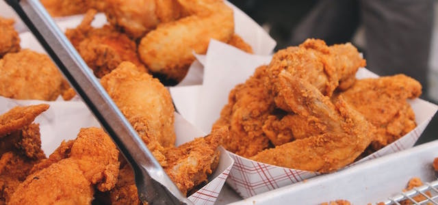 Red and white containers of golden brown crispy chicken.