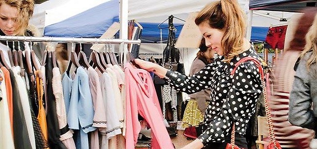 A woman shopping for clothing at an outdoor market in New York City.