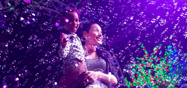 A mother and her daughter enjoying bubbles and colors at Gazillion Bubble Show.