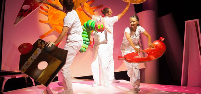 Three actors playing The Very Hungry Caterpillar on stage.
