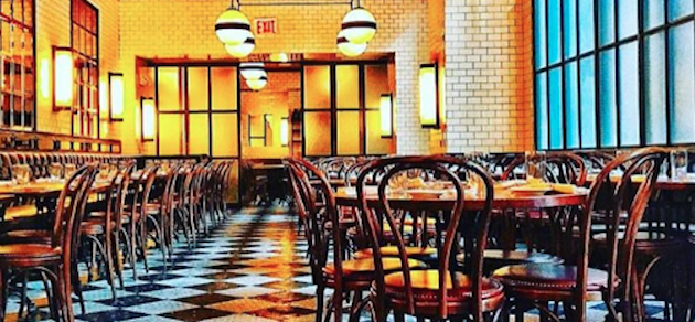 An interior view of The Smith in NYC with warm lighting and wooden tables.