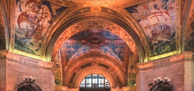 An interior view of a decorated museum with hand painted ceilings.