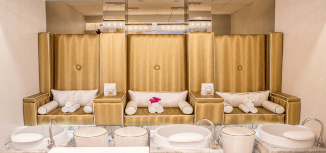 A spa with gold decorations and cushioned chairs in New York City.