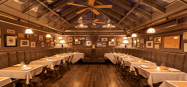 A rustic interior view of Burke & Wills restaurant in NYC with wooden accents and warm lighting.