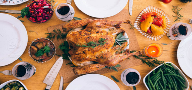 A wooden dining table set for a Thanksgiving meal.