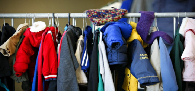 A rack of gently used coats hanging on a rod to donate.