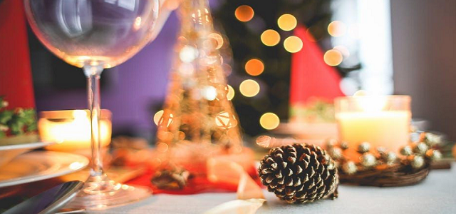 Holiday table decor with glowing lights and an empty wine glass.