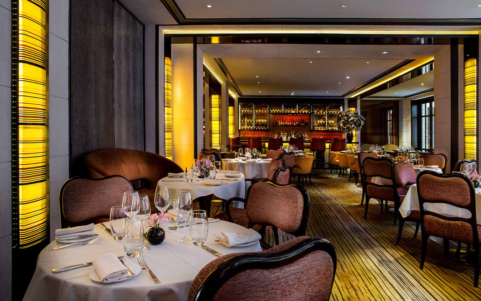 Interior of restaurant, brown chairs, yellow carpet dimmed lights