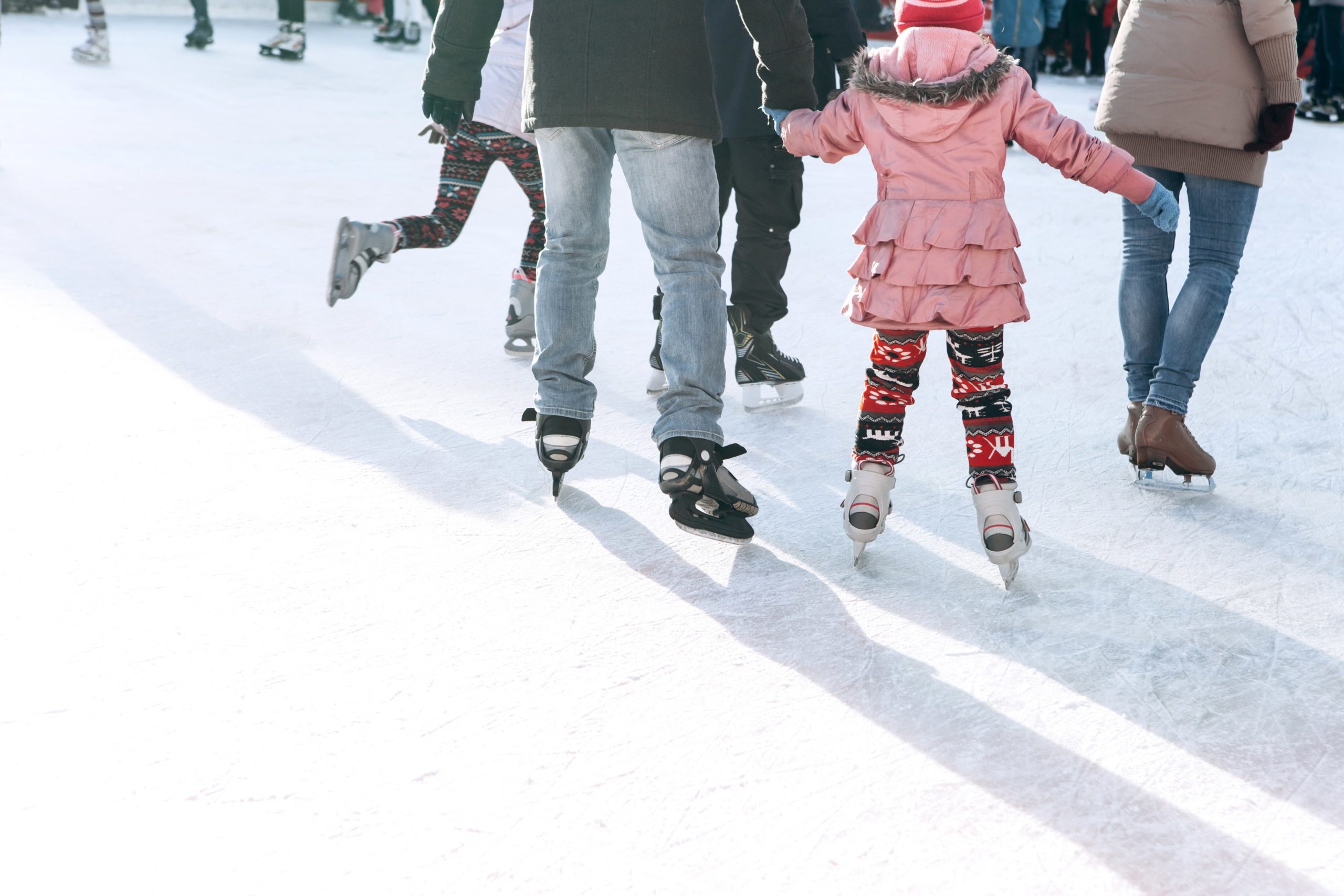 father and daughter ice skating holding hands