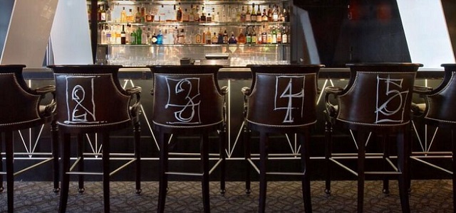 A dark wood bar setting at Cafe Boulud in NYC.