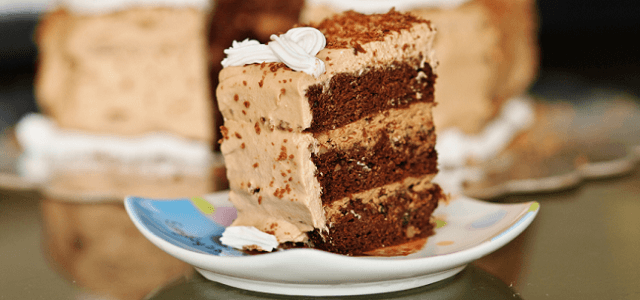 A slice of layered chocolate cake on a colorful plate.