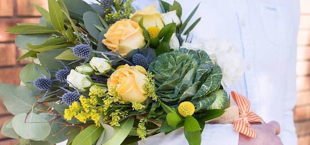 A man holding a bouquet of fresh flowers.