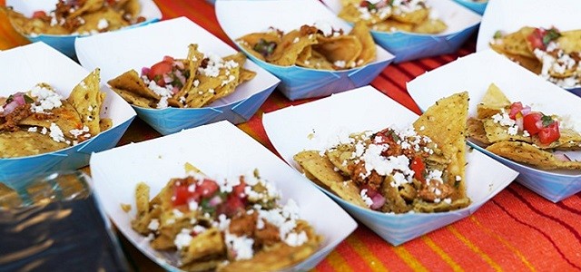 A table set with samples of tacos at a food festival.