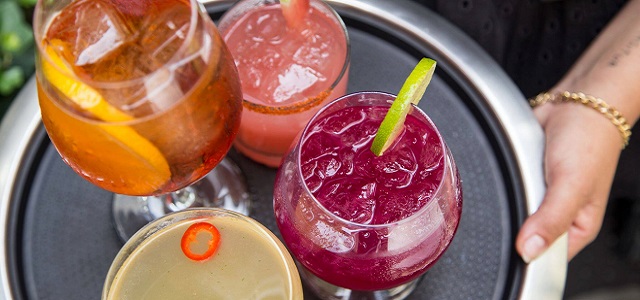 Four colorful drinks on a silver tray at The Little Beet Table in NYC.