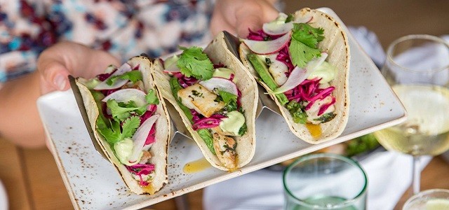 Three gluten free tacos on a white dish at The Little Beet Table in NYC.