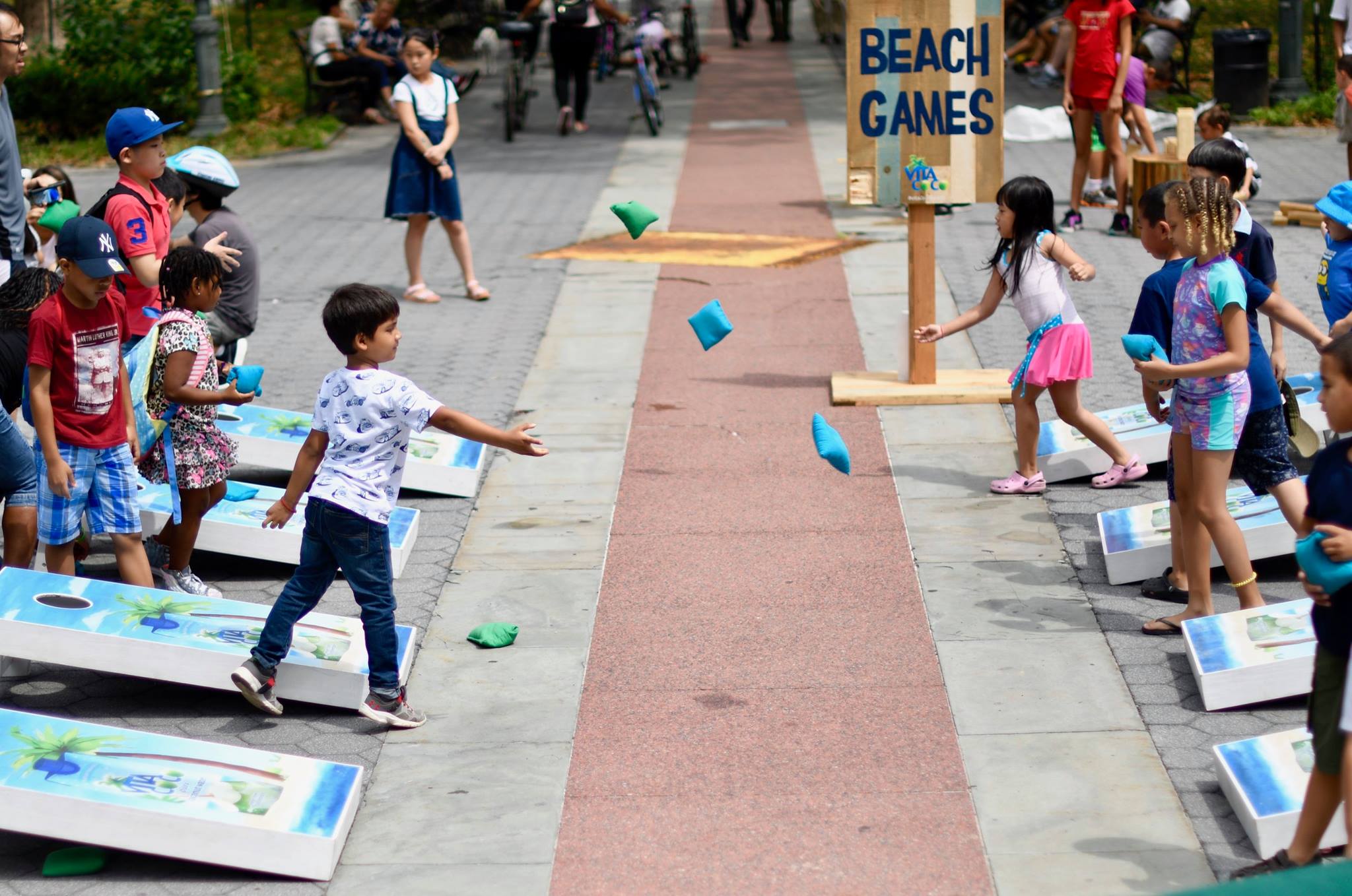 Kids playing corn hole on NYC street