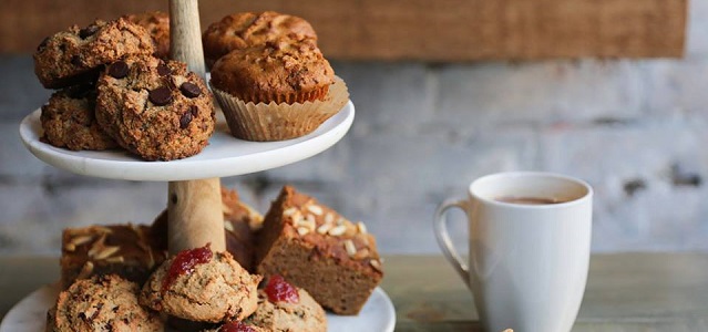 cookies muffins and brownies on a stack able plate and a coffee mug