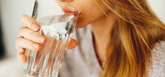 woman drinking water from glass