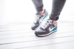 A person in grey sweatpants and sneakers walking