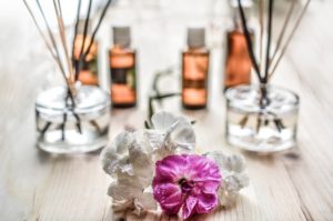 Diffusers and essential oils on a table with floweres