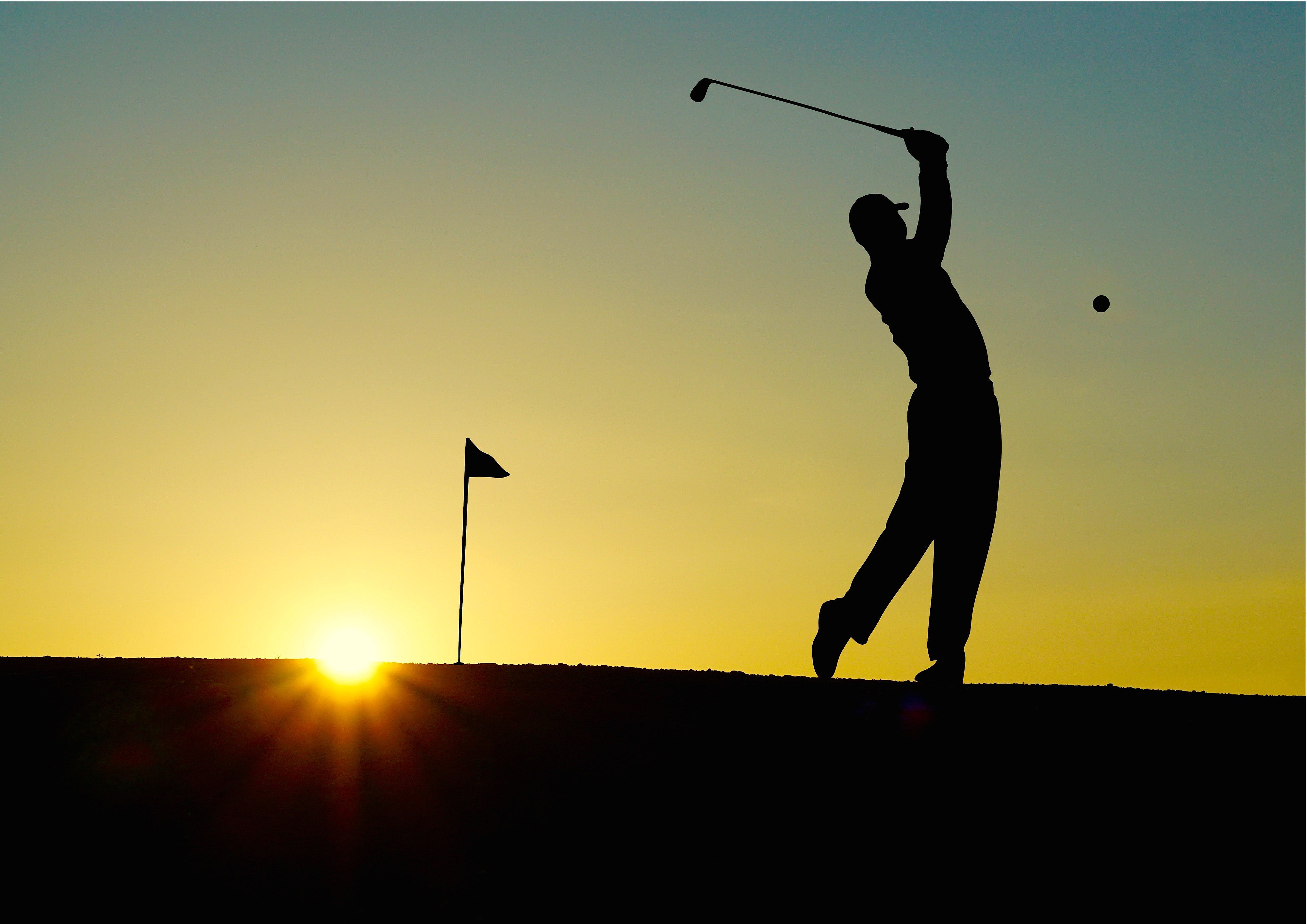 man golfing during sunset