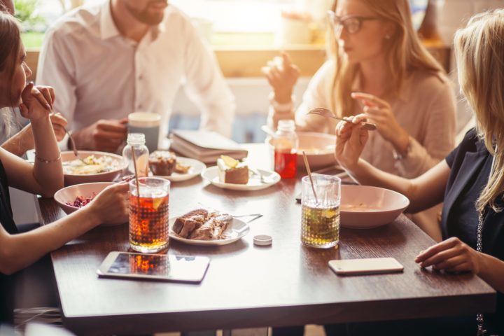 Friends laughing over lunch at a cafe