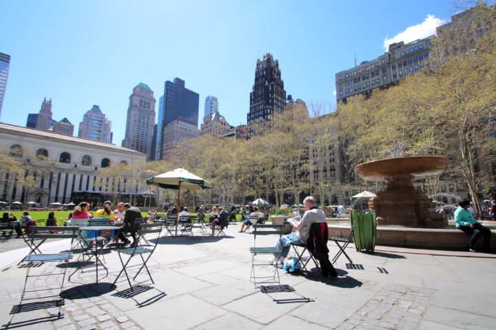 Bryant Park lunch tables with people sitting enjoying a sunny day