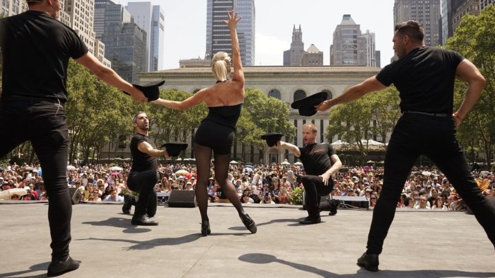 Performers on stage at bryant park singing and dancing