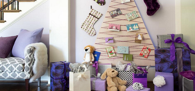 A purple living room with a Christmas tree alternative made up of holiday greeting cards.