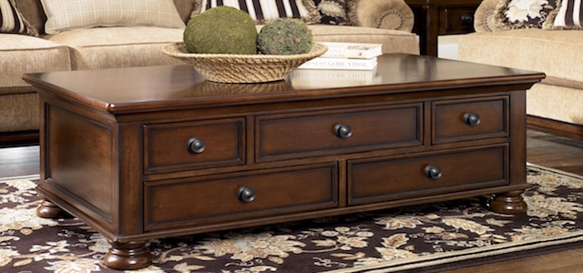 A dark wood coffee table with additional drawers for storage.