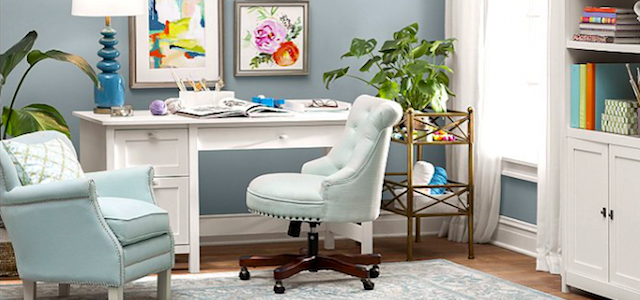 A cozy at home office with light blue walls and a desk.