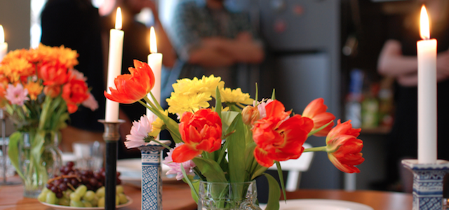 A colorful flower centerpiece display on a table at a dinner party.