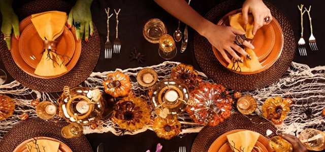 A fall inspired dining room table centerpiece and orange, brown, and tan dishes and accessories.