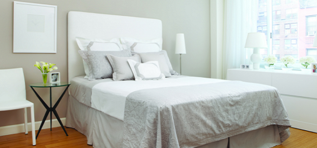 An interior view of a white bedroom within Glenwood's luxury apartments in New York City.