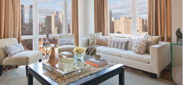 A view of a neutral tone living room at one of Glenwood's luxury apartment buildings overlooking Manhattan.