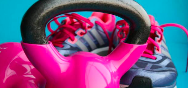 A hot pink dumb bell weight for a home gym.